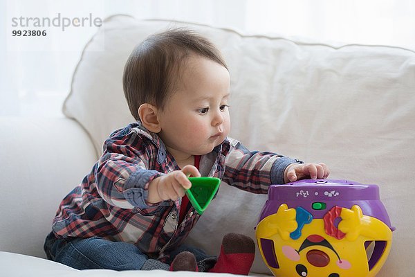 Baby Junge spielt mit Formsortierer Spielzeug