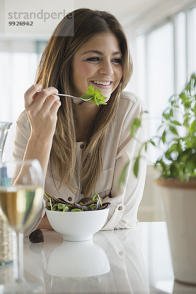 junge Frau junge Frauen Zimmer Salat essen essend isst Wohnzimmer