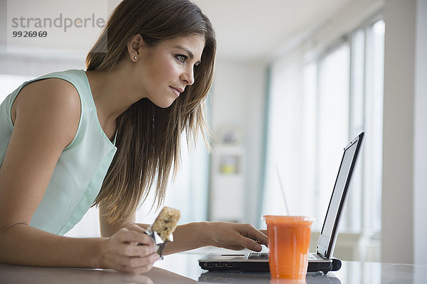 junge Frau junge Frauen Notebook arbeiten Mittagspause Pause essen essend isst