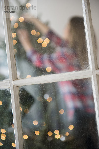 junge Frau junge Frauen Weihnachtsbaum Tannenbaum schmücken