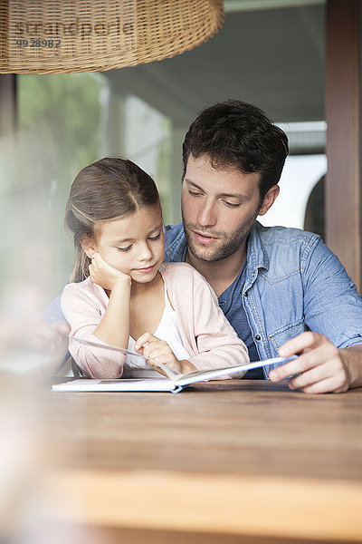 Vater und kleine Tochter beim gemeinsamen Lesen