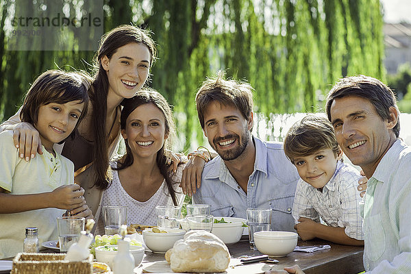 Familie beim gemeinsamen Frühstück im Freien  Gruppenporträt