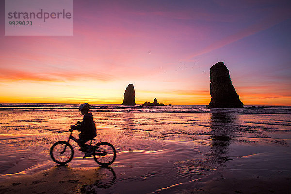 nahe Felsbrocken Europäer Vereinigte Staaten von Amerika USA Strand Silhouette radfahren Anordnung Kanone Mädchen