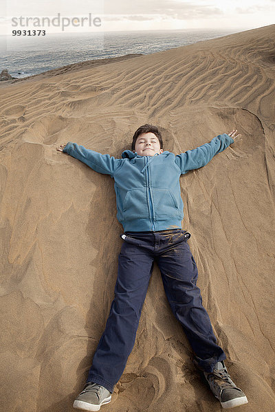 liegend liegen liegt liegendes liegender liegende daliegen Strand Junge - Person Hispanier Sand Düne