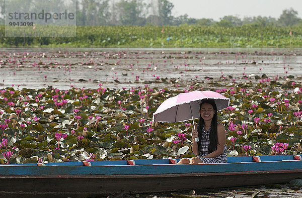 Seerose Frau lächeln Regenschirm Schirm Boot pink jung Tourismus