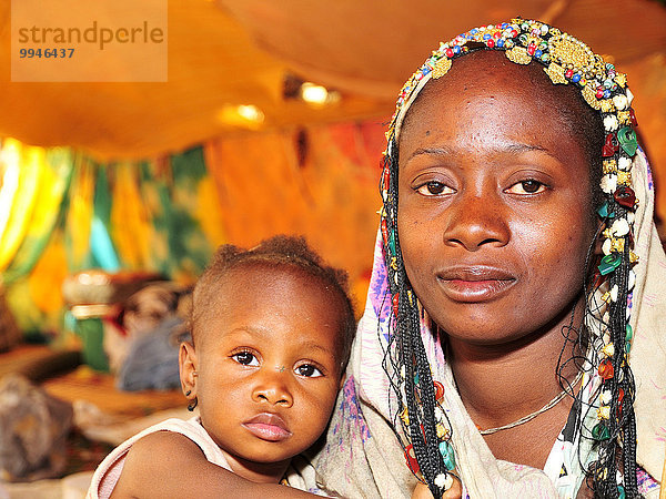 Frau mit Kopfschmuck mit ihrem Kind  Chinguetti  Region Adrar  Mauretanien  Afrika