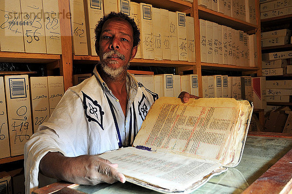 Gelehrter  alter Mann mit wertvollem Buch einer Islamischen Bibliothek in der Altstadt  Chinguetti  Region Adrar  Mauretanien  Afrika