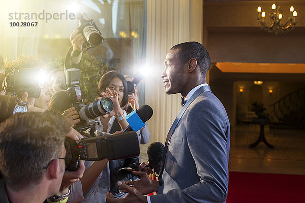 Berühmtheit wird von Paparazzi beim Red Carpet Event interviewt und fotografiert.