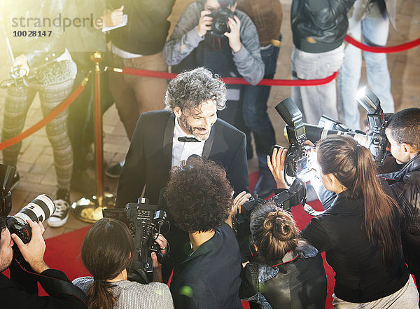 Prominente werden von Paparazzi-Fotografen beim Red Carpet Event interviewt und fotografiert.