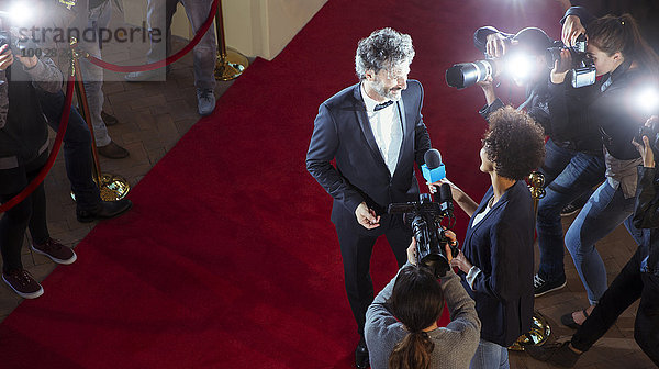 Prominente werden von Paparazzi-Fotografen beim Red Carpet Event interviewt und fotografiert.