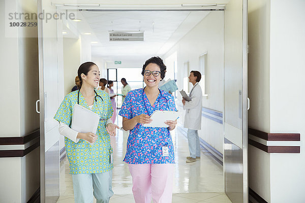 Lächelnde Krankenschwestern reden im Krankenhausflur