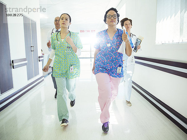 Ärzte und Krankenschwestern laufen den Krankenhausflur entlang