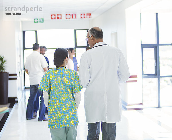 Arzt und Krankenschwester zu Fuß im Flur des Krankenhauses