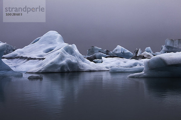 Blaue Eisberge im ruhigen Wasser  Jokulsarlon  Island