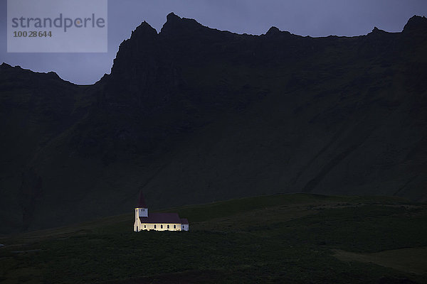 Beleuchtete Kirche unter Felsen  Vik  Island