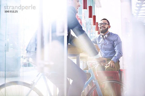 Lächelnder Mann auf dem Fahrrad im Café