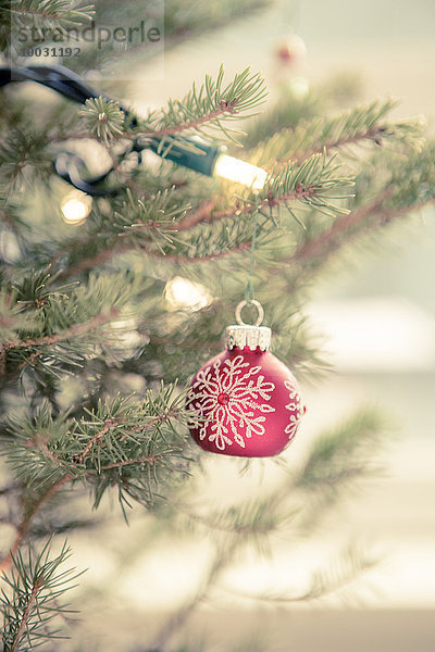 Rote Ornamente und Lichterketten am Weihnachtsbaum