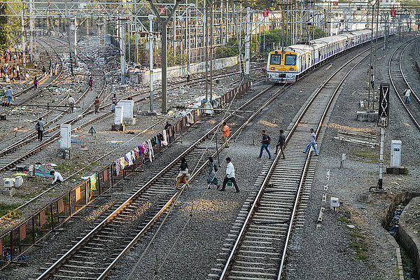 Menschen überqueren Gleise bei einfahrendem Zug  Mumbai  Maharashtra  Indien  Asien
