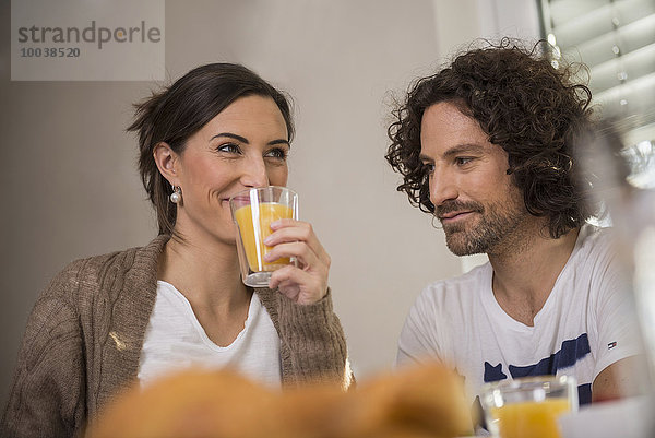 Mid adult woman drinking juice while her husband looking at her  Munich  Bavaria  Germany