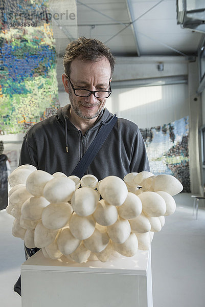 Mature man looking at eggshell lampshade in an art museum  Bavaria  Germany