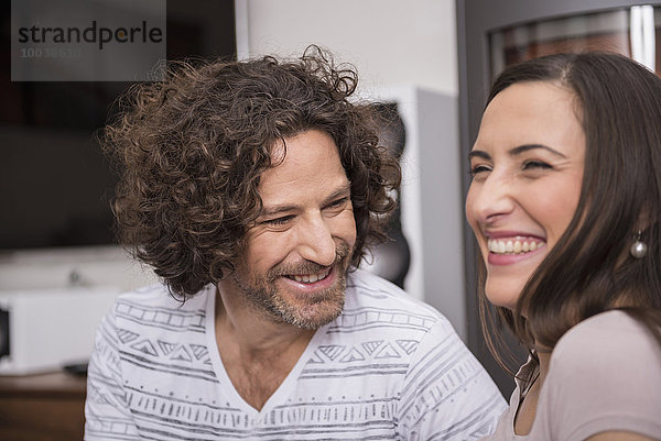 Close-up of mid adult couple smiling in living room  Munich  Bavaria  Germany