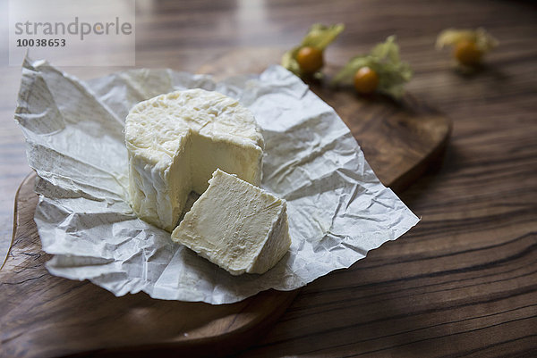 Close-up of white cheese with slice on chopping board  Germany