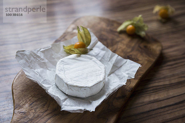 Close-up of white cheese and gooseberry on chopping board  Germany