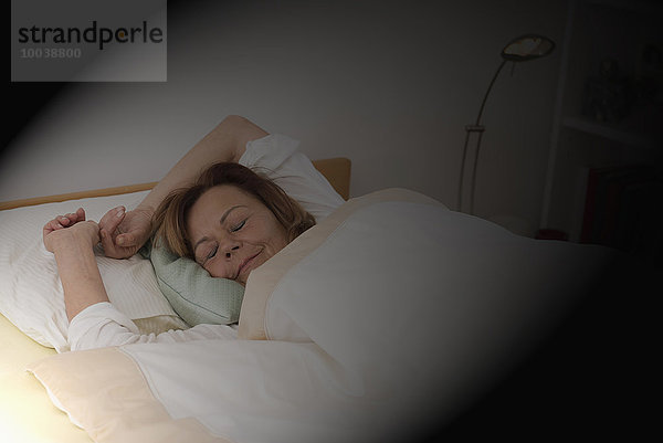 Senior woman sleeping on bed in bedroom  Munich  Bavaria  Germany