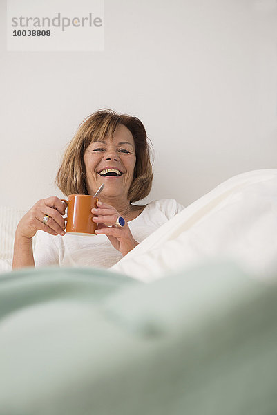 Senior woman at her bedroom drinking tea in the morning  Munich  Bavaria  Germany