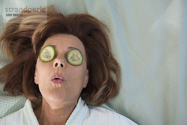 Senior woman with cucumber slices on her eyes  Munich  Bavaria  Germany