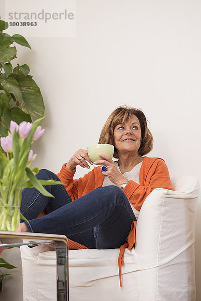 Senior woman dreaming while drinking tea at home  Munich  Bavaria  Germany