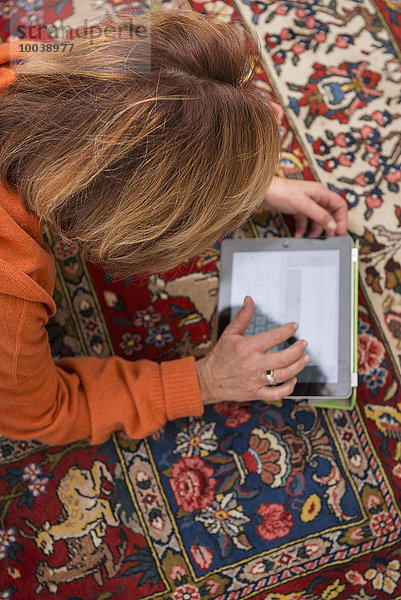 Relaxed senior woman working a digital tablet  Munich  Bavaria  Germany