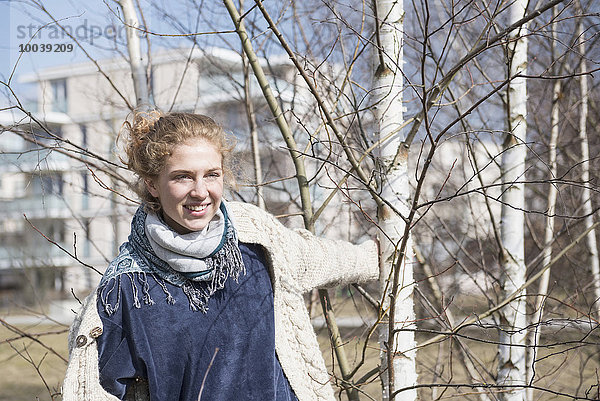 Young woman playing with birch tree  Munich  Bavaria  Germany