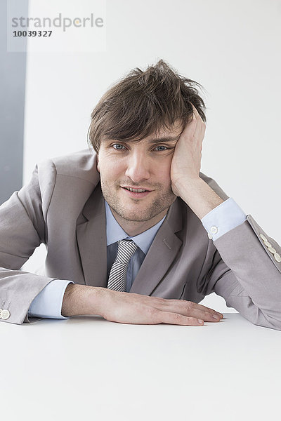 Businessman leaning on desk in office  Leipzig  Saxony  Germany