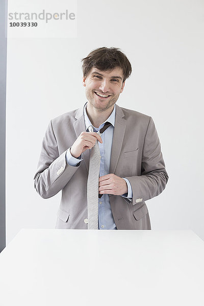 Businessman adjusting his tie  Leipzig  Saxony  Germany