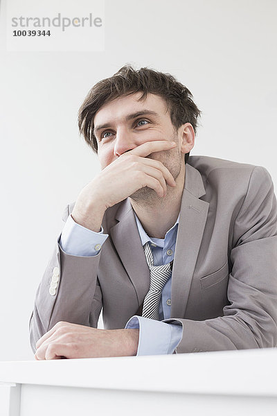 Businessman leaning on desk in office  Leipzig  Saxony  Germany