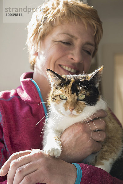 Close-up of mature woman with cat in her arms  Bavaria  Germany