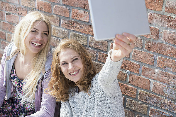 Two friends taking selfie with her digital tablet  Munich  Bavaria  Germany