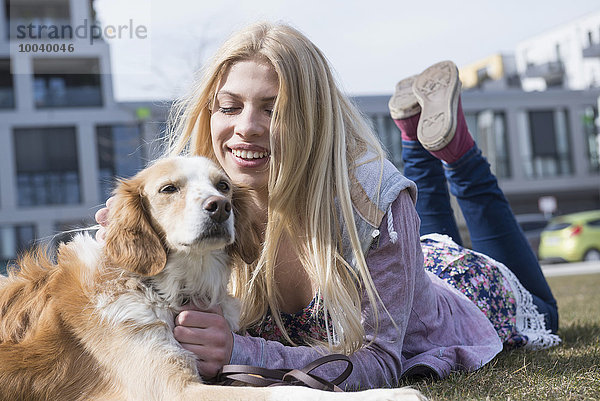 Teenage girl lying in park with her dog  Munich  Bavaria  Germany