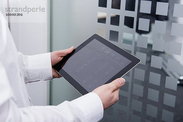 Man operating digital tablet in office  Munich  Bavaria  Germany