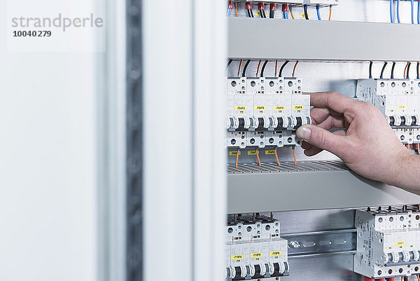 Close-up of electrician switching electrical fuse in distribution fusebox  Munich  Bavaria  Germany