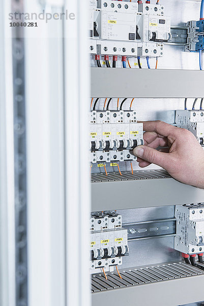 Close-up of electrician switching electrical fuse in distribution fusebox  Munich  Bavaria  Germany