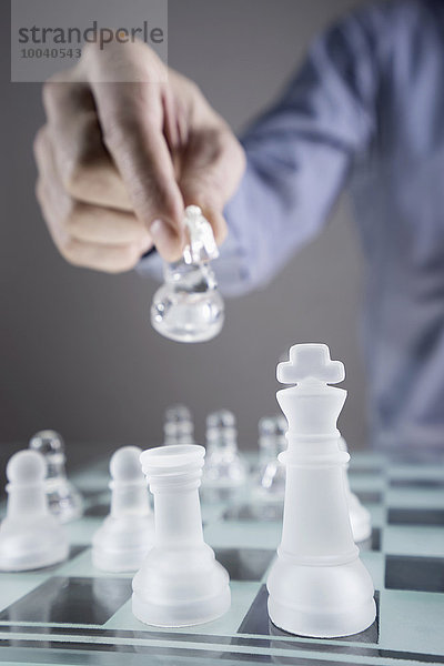 Close-up of man's hand going for checkmate while playing chess  Bavaria  Germany