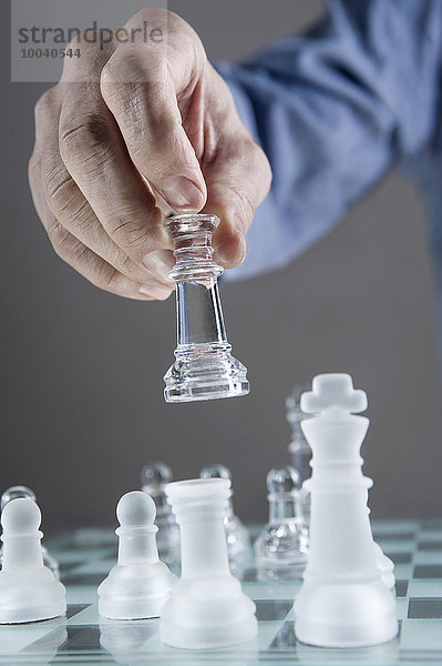 Close-up of man's hand going for checkmate while playing chess  Bavaria  Germany