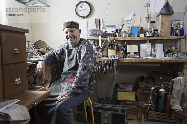 Senior male goldsmith smiling in workshop  Bavaria  Germany