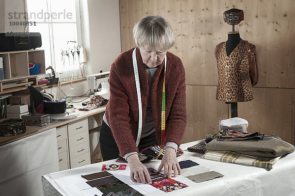 Senior female fashion designer working in workshop  Bavaria  Germany