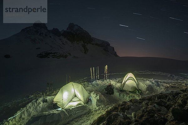 Tents lit up at night in the snow