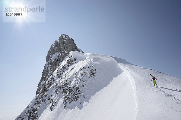 Ski mountaineer climbing on snowy peak  Tyrol  Austria