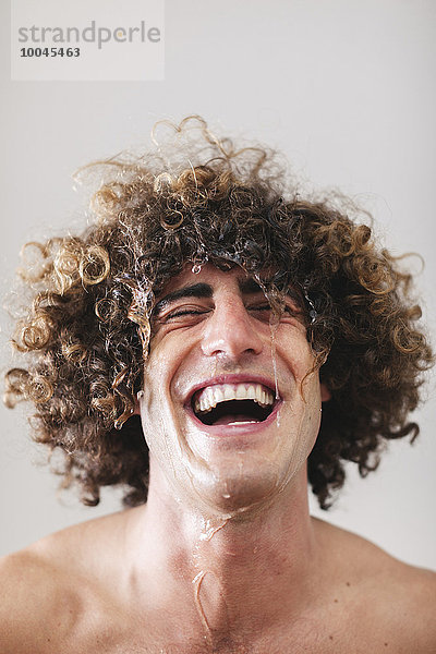 Porträt eines lachenden Mannes mit nassem lockigem Haar