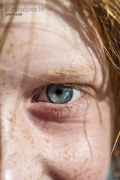 Blaues Auge eines Jungen mit Sommersprossen